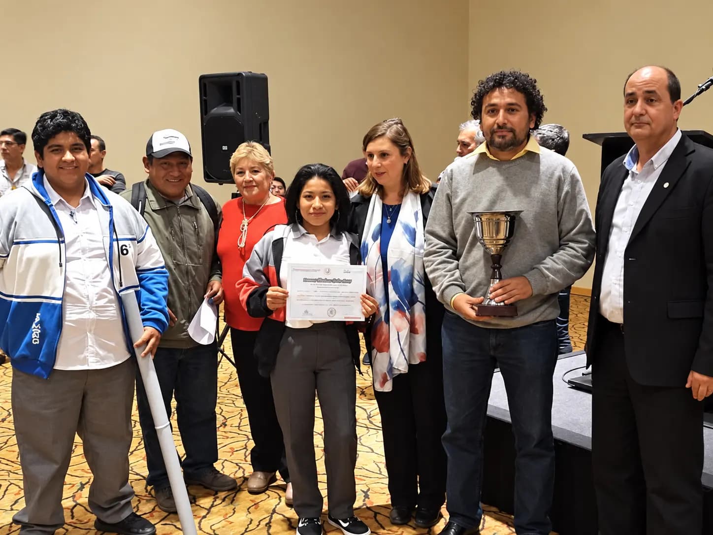 Una alumna con el certificado y un docente con la copa, junto al equipo y el bastón inteligente, en la entrega de INNOVA Salta